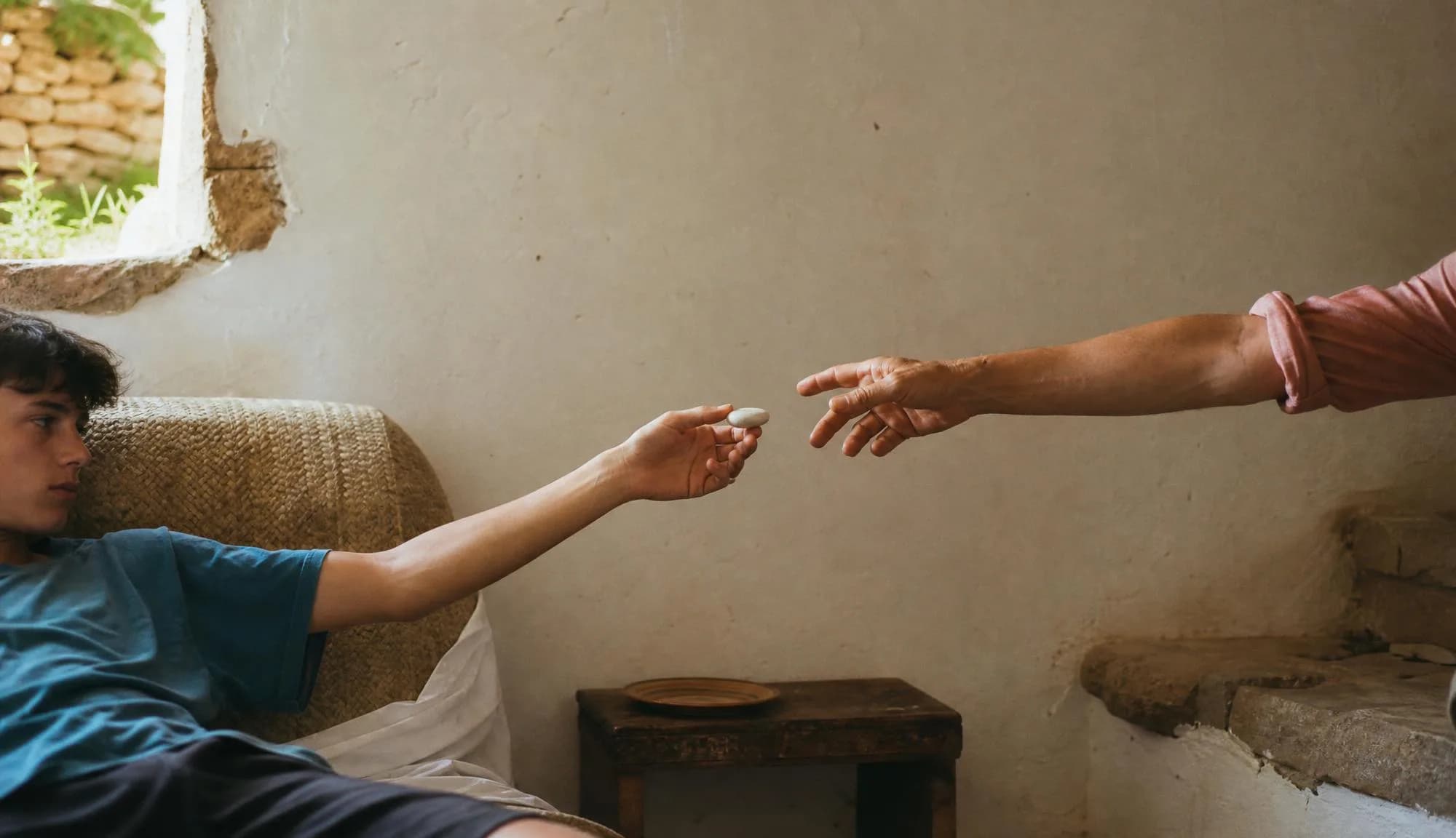 Hands reaching toward one another with the device between them.
